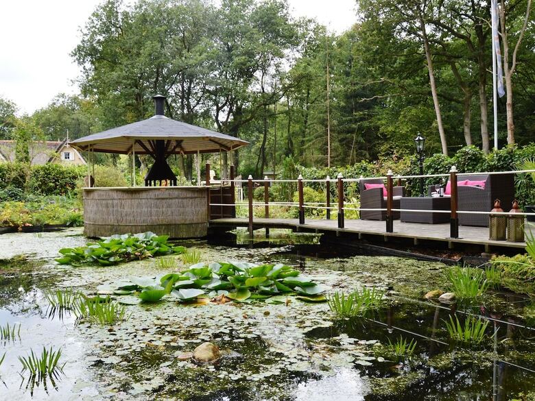 A Detached Bungalow With Outdoor Fireplace, Covered Terrace And Pond In A Forest Plot